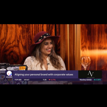 Woman in a red hat smiling during an interview about aligning personal brands with corporate values.